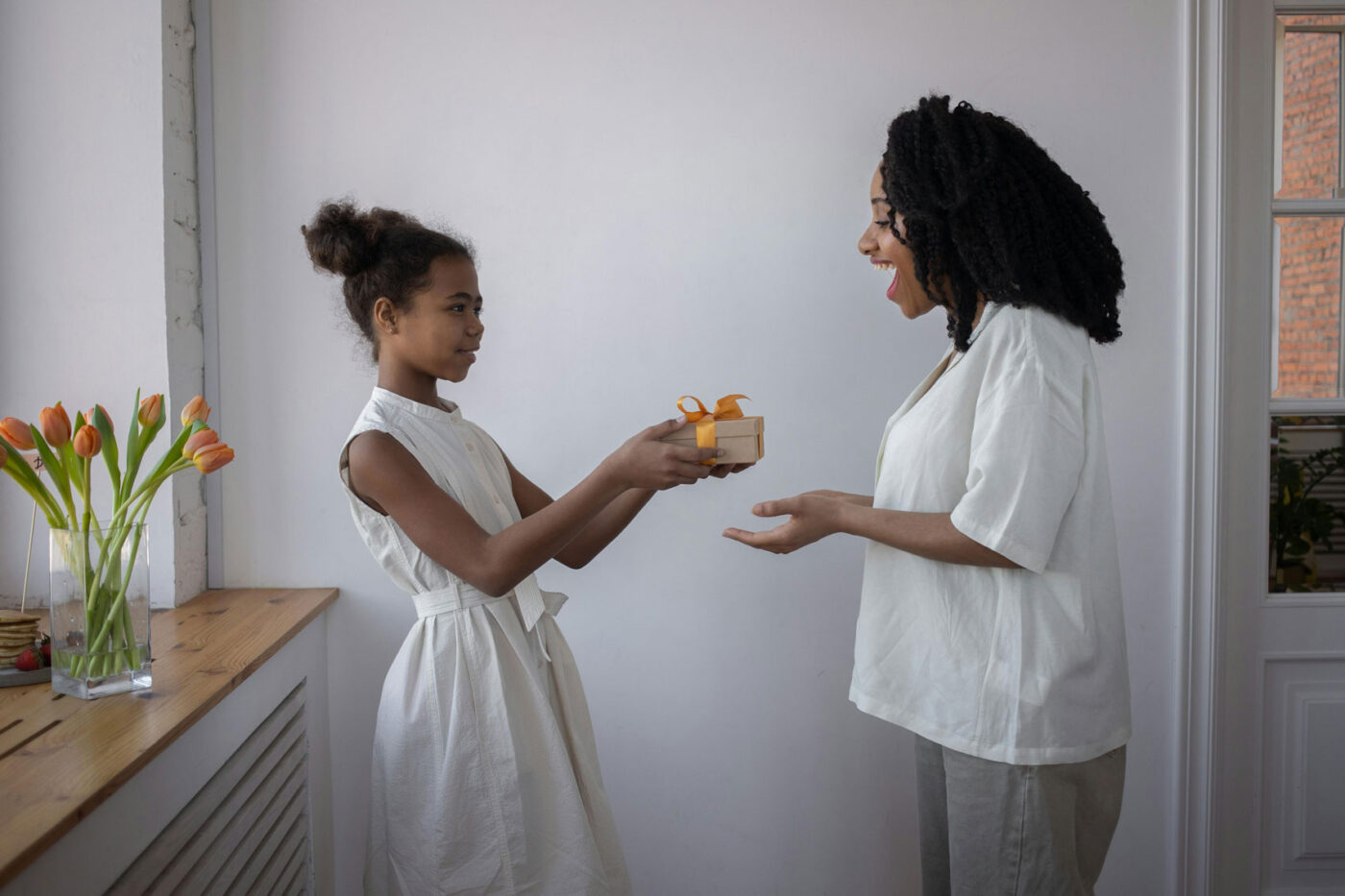 Dochter geeft cadeau aan haar moeder voor Moederdag of verjaardag in huiselijke setting