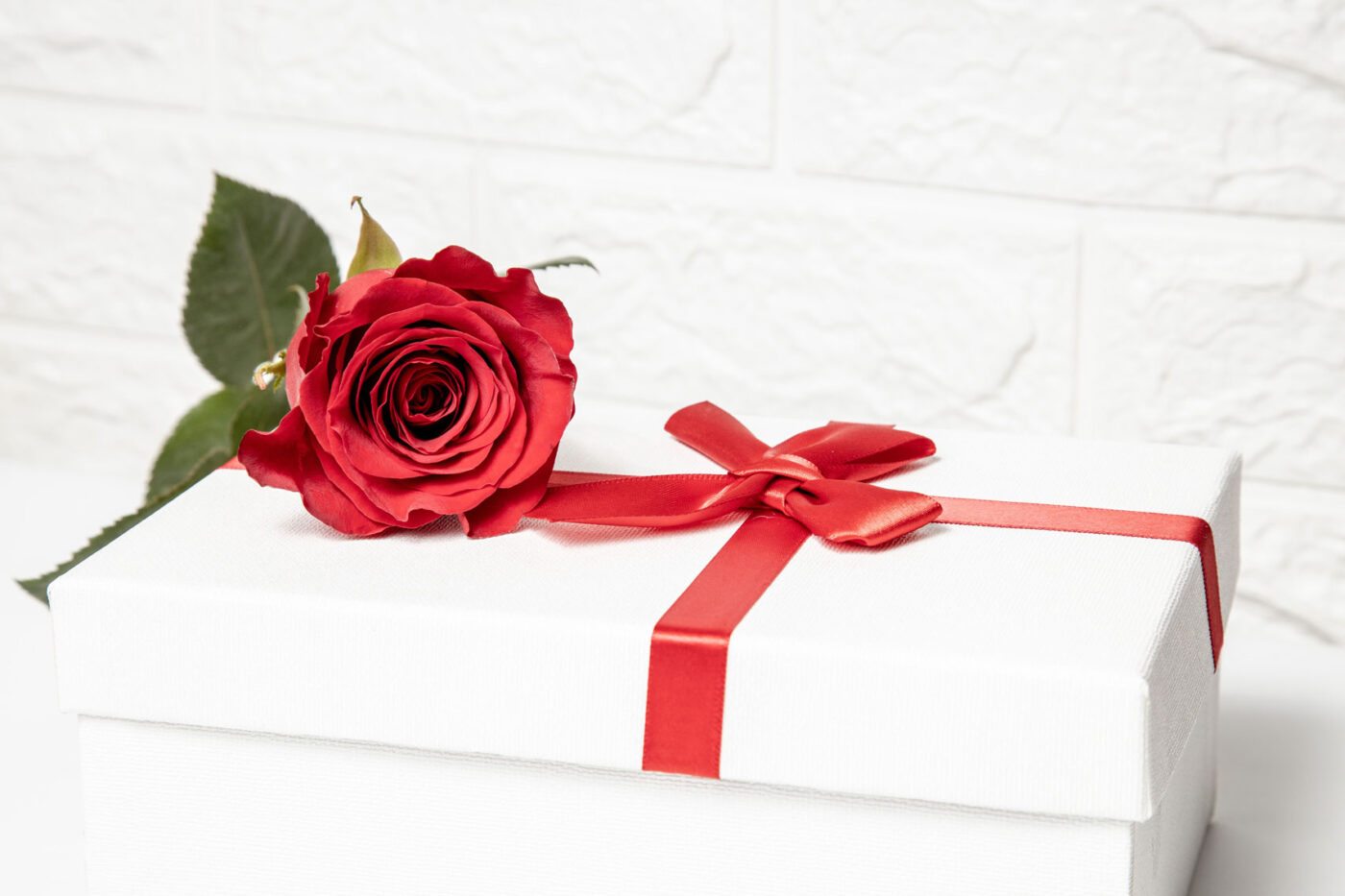 Persoonlijk Valentijnscadeau met rode roos op een cadeauverpakking als symbool voor een blijvend sieraad met emotionele betekenis.